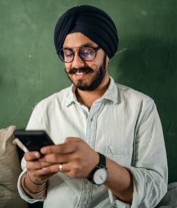 Indian Man Wearing Turban Playing on Cell Phone